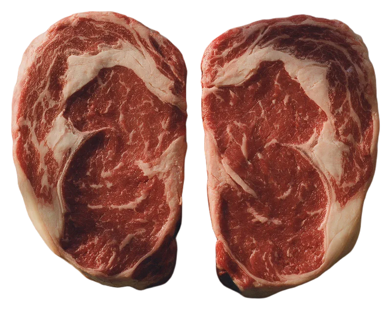 Two thick raw scotch fillet steaks with heavy marbling.